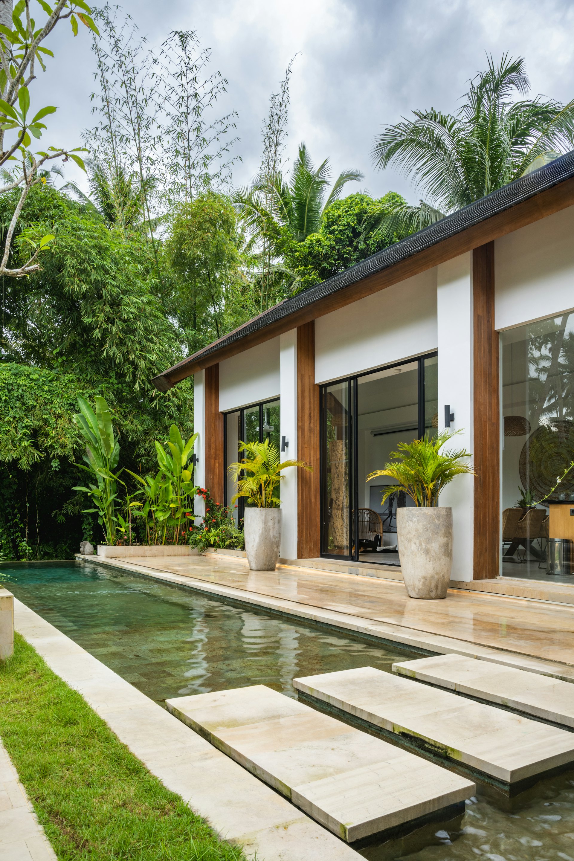 Villa tropis dengan kolam di tengah taman